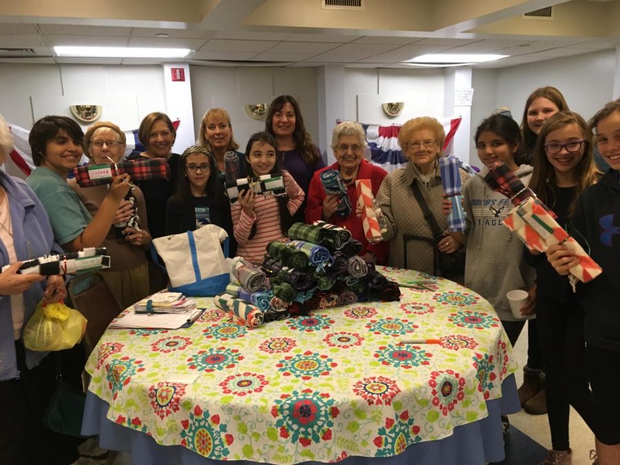 Ms. Mittan and the 7th Grade No Place For Hate Club posing with the seniors after making clothing items for the homeless.